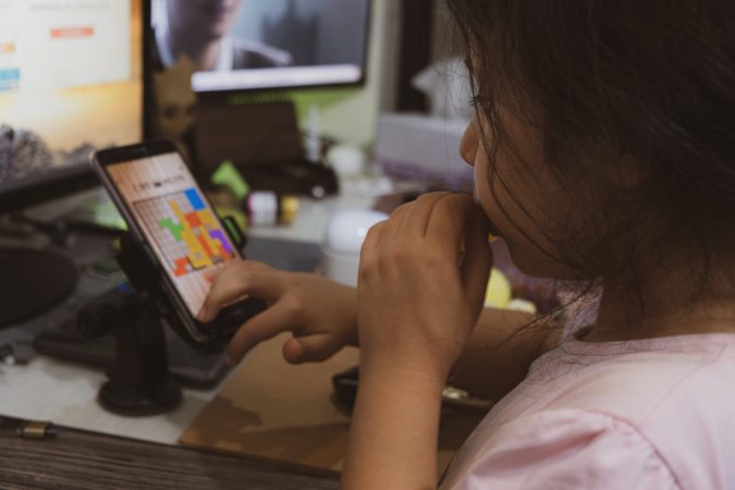 sajad-nori-1cMVyPpwwJk-unsplash Young girl playing game on smartphone