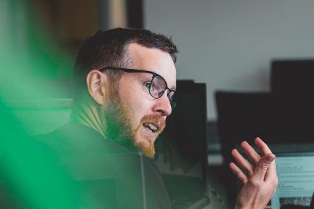 Man looking over shoulder whilst speaking in office environment